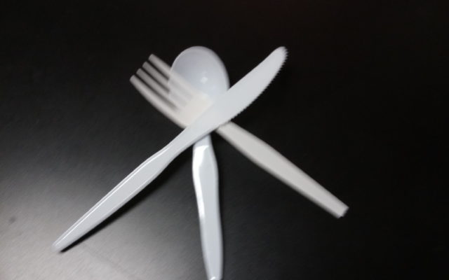 Plastic fork, knife and spoon, crossed over each other, on a table. Photo by Alpha Media Palm Springs Ca