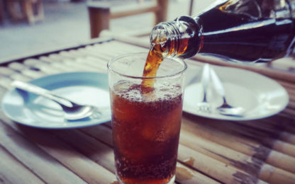 CocaCola being poured from a plastic bottle into a glass on a table at a restaurant. Photo from Alpha Media Portland OR
