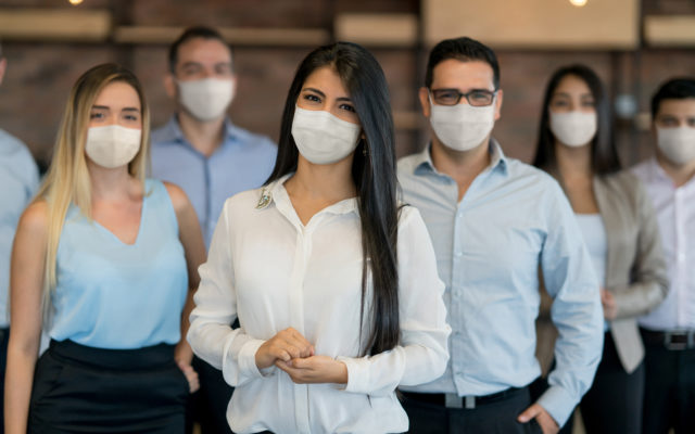 Group of business people working at the office wearing facemasks to avoid the spread of coronavirus during the COVID-19 pandemic. Photo from Alpha Media Portland OR