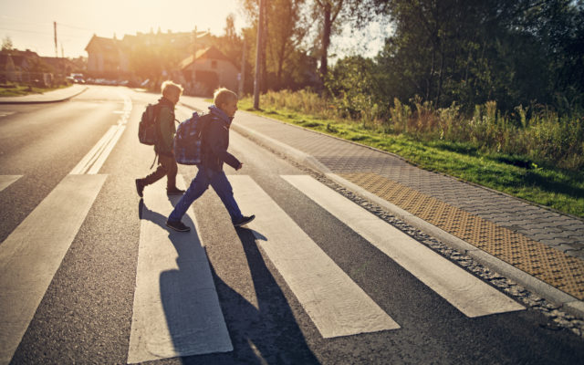 Two school boys walking in a crosswalk, heading to school on a sunny morning. Photo from Alpha Media Portland OR