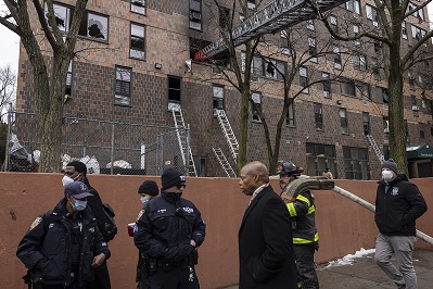 New York City Mayor Eric Adams, third right, walks by an apartment building where a deadly fire occurred in the Bronx on Sunday, Jan. 9, 2022, in New York. (AP Photo/Yuki Iwamura) use locally Jan 9th 2022 @ap.images